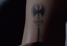 Close up of an arm with a labrys tattoo